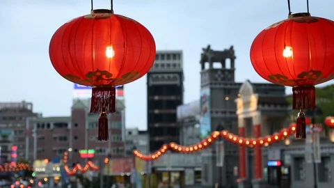 Pair of Glowing Light Red Asian Paper Lanterns Hanging with City Street Behind Stock-Footage 101932390