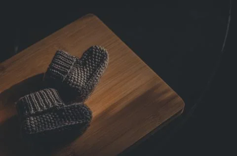 A pair of gray booties for a small child. Early morning, light from the window. Stock Photos