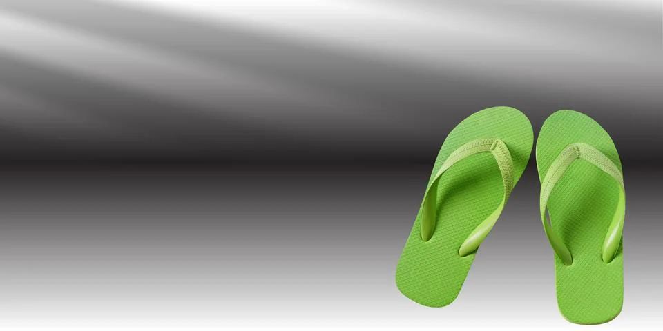 A pair of green flip-flops is placed on a smooth, gradient background transition Stock Photos