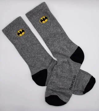 A pair of grey casual socks featuring the iconic batman logo. Stock Photos