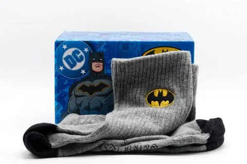 A pair of grey casual socks featuring the iconic batman logo and package. Stock Photos
