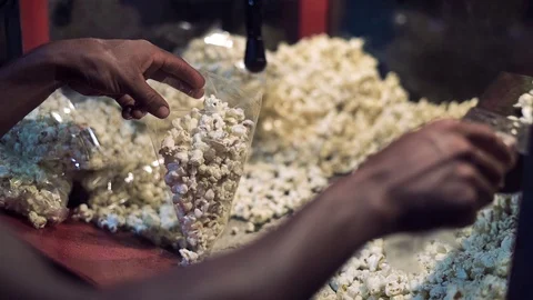 A Pair Of Hand Suffling PopCorns In a Table preparing for packing them Stock Footage 97361877