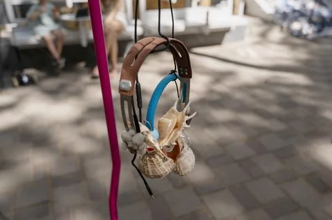 Pair of handmade shell headsets on a sidewalk. Symbol of listening to nature Stock Photos
