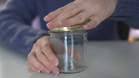 A pair of hands carefully opening a beautiful glass jar that features an elegant Stock Footage 318544129