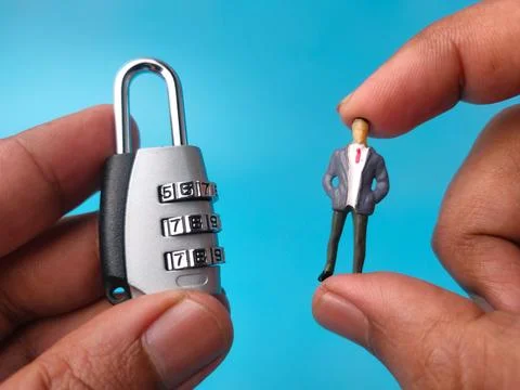 A pair of hands displays a silver combination padlock on the left and a min.. Stock Photos