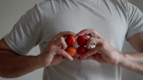A pair of hands gracefully displaying ripe apricots, emphasizing their vivid Stock-Footage 310789648