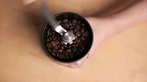 A pair of hands grinding coffee beans using a manual coffee grinder Stock Footage 140751941