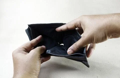 A pair of hands holds an open, empty black leather wallet. The wallet's int.. 스톡 사진