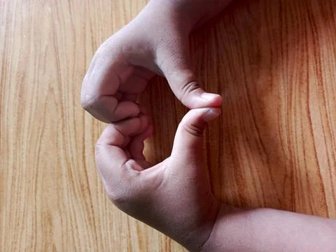 A pair of hands join together to form a heart pattern Stock Photos