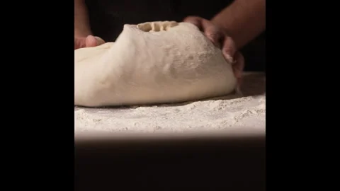 A pair of hands kneading dough on a floured countertop Stock Footage 315304216