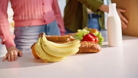 Pair hands putting shoppings kitchen closeup. Happy lesbian couple sorting food Vídeo Stock 335103917