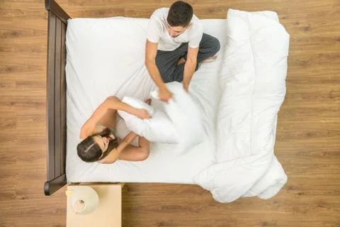 The pair have a fun on the bed. View from above Fotos Stock