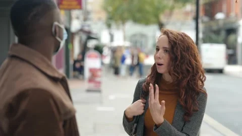 Pair having argument about wearing masks on pavement Stock Footage 141385003