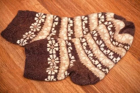 Pair of knitted woolen socks lying on the floor Stock Photos