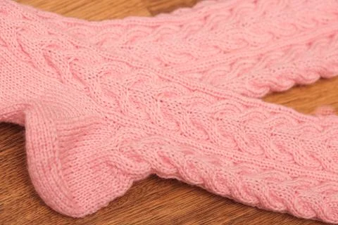 Pair of knitted woolen socks lying on wooden floor Foto stock