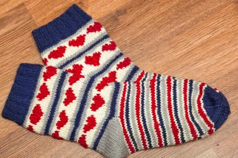 Pair of knitted woolen socks lying on the floor Stock Photos