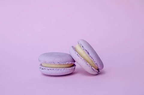 Pair of lavender French macarons on solid lilac background, purple monochro.. Fotos Stock