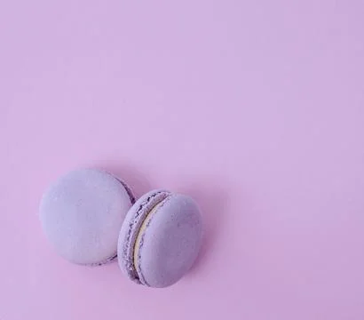 Pair of lavender French macarons on solid lilac background, purple monochro.. Fotos Stock