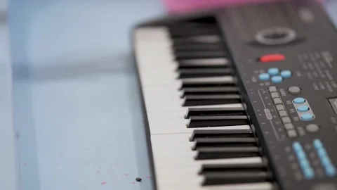 A pair of little hands are playing the electronic organ Stock Footage 157853754