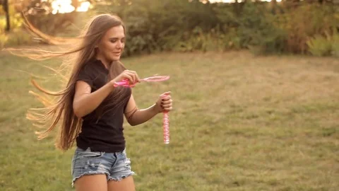 Pair of lovers blowing bubbles outdoors Stock Footage 77525381