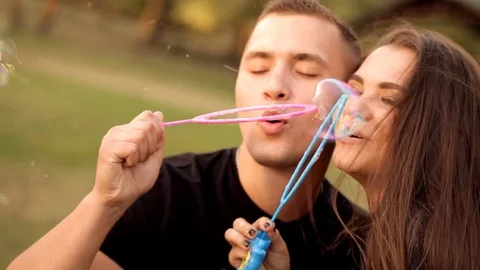 Pair of lovers blowing bubbles outdoors Stock-Footage 77525616