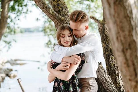 A pair of lovers posing on the camera. A couple of lovers in the park posi... Fotos Stock