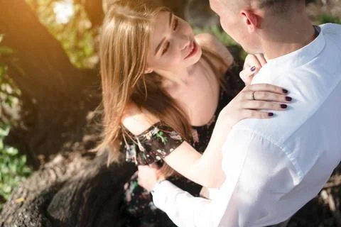 A pair of lovers posing on the camera. A couple of lovers in the park posi... Fotos Stock