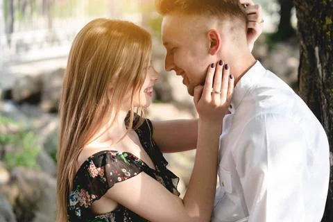 A pair of lovers posing on the camera. A couple of lovers in the park posi... Fotos Stock