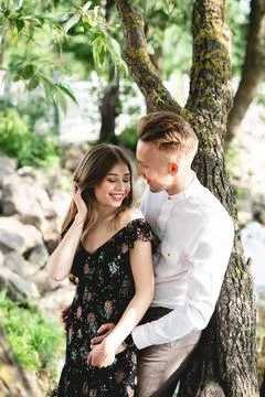 A pair of lovers posing on the camera. A couple of lovers in the park posi... Fotos Stock
