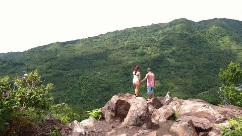 A pair of lovers stands at the cliff and hug each other. Video stock 122903681