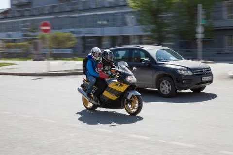 A pair of men in a red biker jacket and a woman in blue both in protective he Fotos Stock