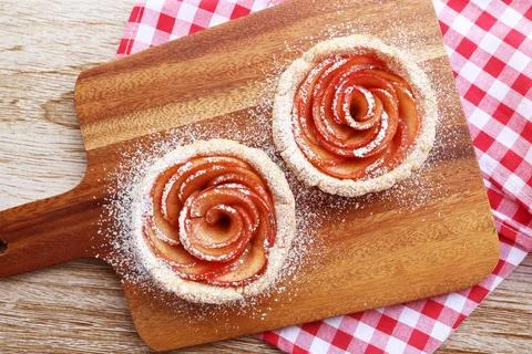 Pair of Mini Apple Rose Shaped Tartlets Sprinkled with Powdered Sugar Stock Photos