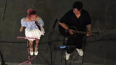 A pair of musicians performing on an evening street Stock Footage 340331253