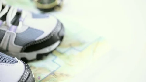 Pair of new womens hiking shoes with topo map on a wood background. Stock Footage