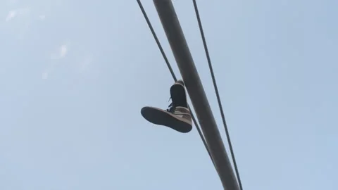 Pair of Nike shoes hanging on pole in the street 스톡 동영상 335306781