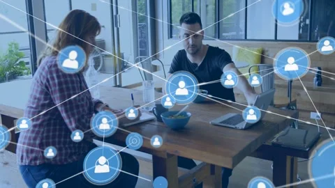 Pair noting, gesturing laptop, blue icon appearing expanding into network Stock Footage 333299010