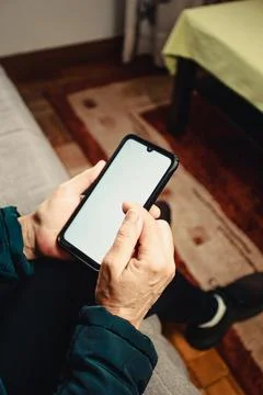 Pair of old hands scrolling over a white screen with copy space phone in a .. Stock Photos