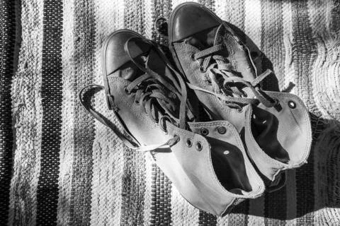 Pair of old sneakers standing on old carpet Stock Photos
