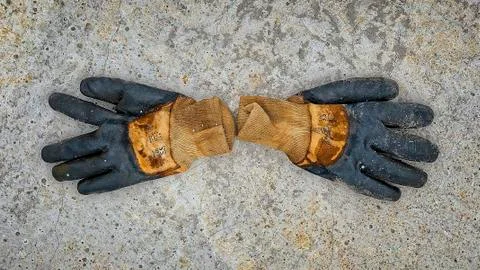 A pair of old work gloves over a reinforced concrete slab, at construction si Stock Photos