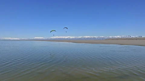 Pair of Paragliders over the great salt lake in Utah Stock Footage 302947018