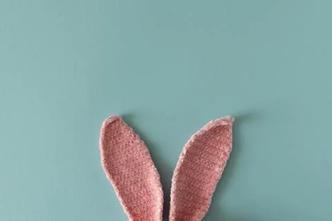 Pair of pink textured Easter bunny ears positioned against soft blue backgrou Stock Photos