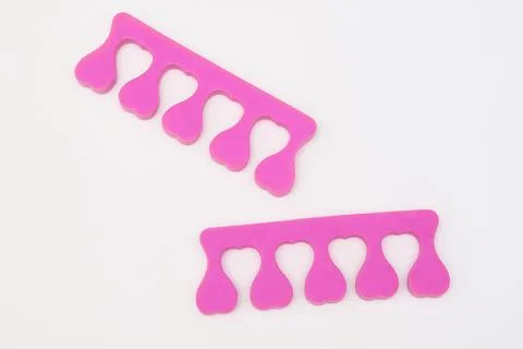 A pair of pink toe separator on white background, pedicure concept Stock Photos