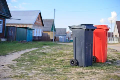 Pair of plastic garbage bins for selective waste disposal on a village stre.. Stock Photos
