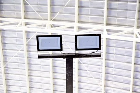 A pair of rectangular LED floodlights mounted on a black pole under a metal.. Fotos Stock