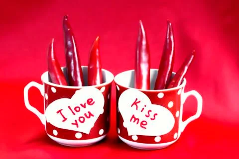 A pair of red cups in polka dots stand on the table. Two white hearts made of Stock Photos