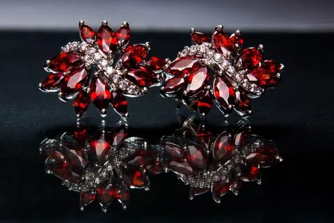 A pair of red ruby crystal luxury earrings on a black surface Stock Photos