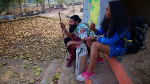 Pair rests on stone steps using hiking poles outdoor Stock Footage 304502622