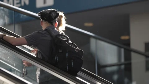 Pair Rides Escalator At Station While Traveling On Sunny Day Stock Footage 124764532