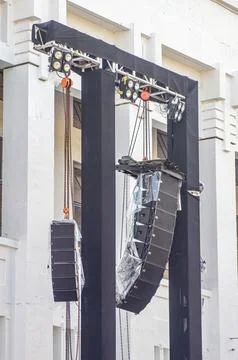 A pair of rigging, lighting, and line array speakers at a concert or large .. Stock Photos