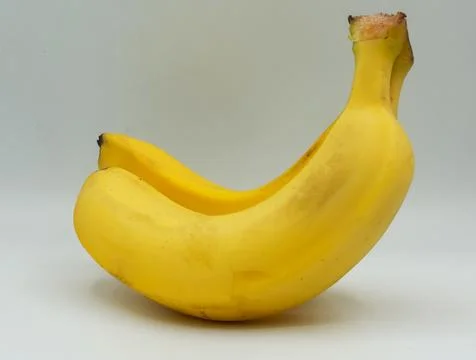 Pair of ripe bananas placed parallel to each other on a clean white background. Stock Photos